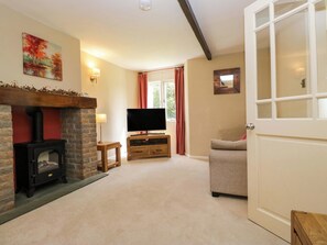 A cozy living room with a fireplace, a television, and a comfortable sofa.