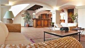 Amplia sala de estar con techo alto, muebles de madera y una distribución central de los asientos.