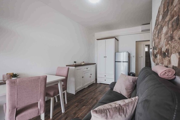 Un espacio habitable compacto con kitchenette, comedor y sofá.