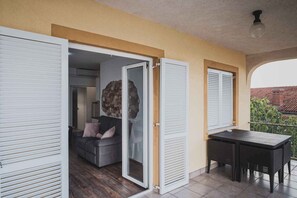 Puerta corredera abierta que da a una sala de estar con sofá y decoración de pared de piedra.