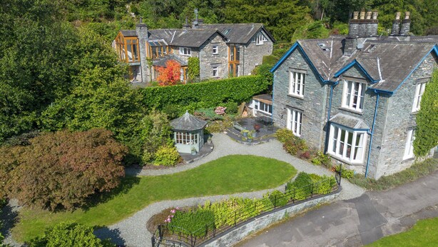 A stone house with a well-maintained garden, a gazebo, and a winding driveway.