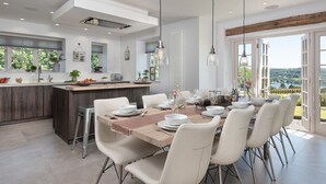 A modern kitchen with a dining area, large windows, and a view of the outdoors. - Hawkrigg Farm (Ambleside)