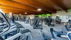 Ein Fitnessraum mit unterschiedlichen Trainingsgeräten, darunter Laufbänder und Kraftgeräte.