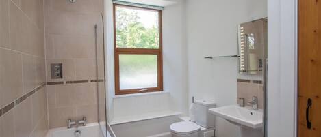Un baño moderno con bañera, inodoro y lavamanos.