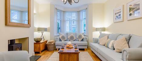 A living room with a fireplace, a chandelier, a sofa, and a coffee table.