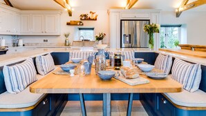 A modern kitchen with a built-in island, stainless steel appliances, and a chandelier. - The Farmhouse - Within the Helland Barton Farm Collection (Delabole)