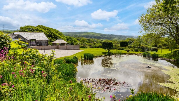 A countryside property with a pond, stone buildings, and lush greenery. - The Farmhouse - Within the Helland Barton Farm Collection (Delabole)