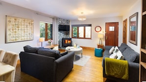 A cozy living room with a fireplace, sofas, and a coffee table. - Brooklands (Ambleside)