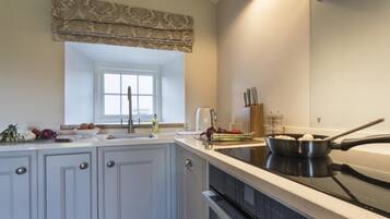 A kitchen with a window, a sink, a stove, and various kitchen items.