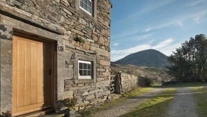 A stone building with a wooden door and a small window. - Cedar Nook (Cockermouth)