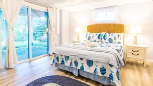 Quarto com uma cama grande, duas mesas de cabeceira e vista para o exterior.