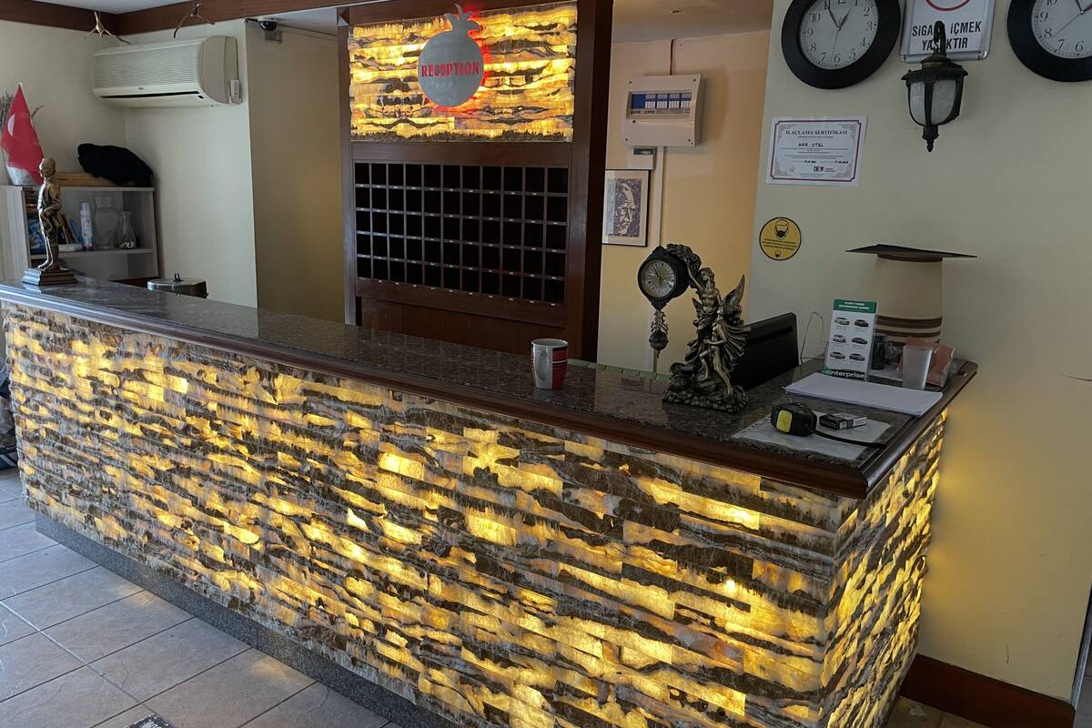 A reception desk with a stone facade and a sign indicating a reception area.