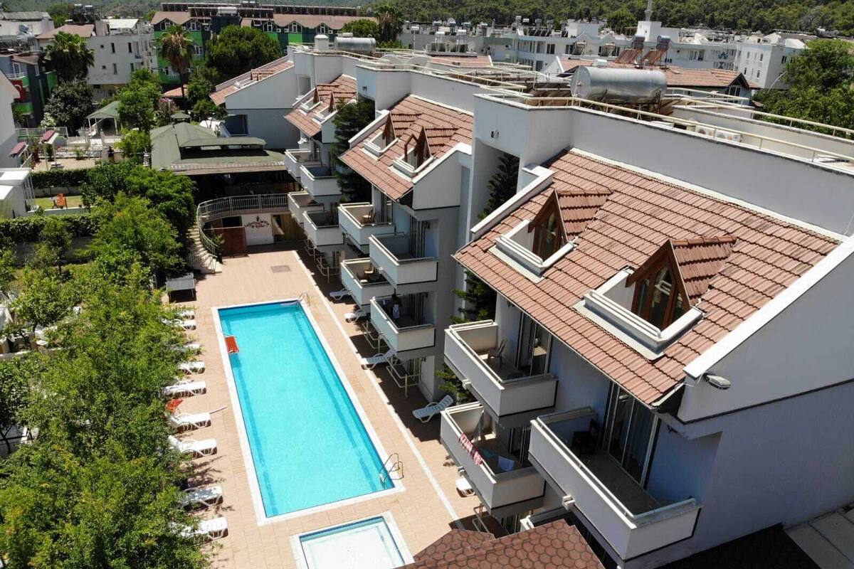A high-rise hotel with a rooftop swimming pool and multiple balconies.
