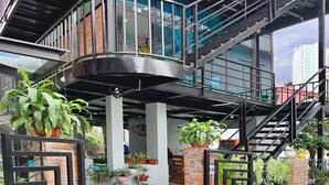 Un bâtiment moderne doté d’une façade en verre, de nombreux balcons et d’une base en briques.