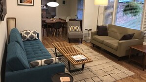 A living room with a blue sofa, a beige sofa, a wooden coffee table, and a dining area with a table and chairs. - 7 Miles to Masters Tournament - Less Traffic - Sleeps 8 (North Augusta)