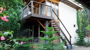 Un bâtiment à deux étages doté d’un balcon en bois et d’un escalier menant à l’étage supérieur.