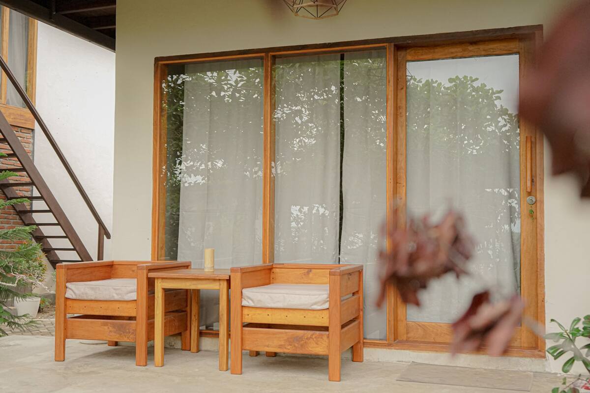 A wooden bench and table set against a sliding glass door with frosted glass panels.