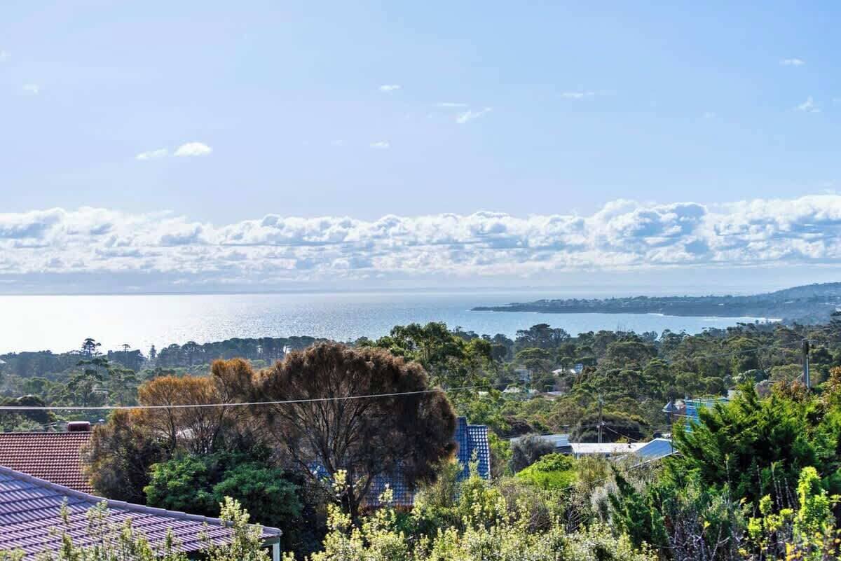 A coastal landscape with a view of the sea and distant hills.