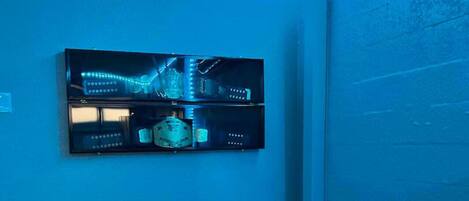 A room with a desk, chair, and a wall-mounted display unit.