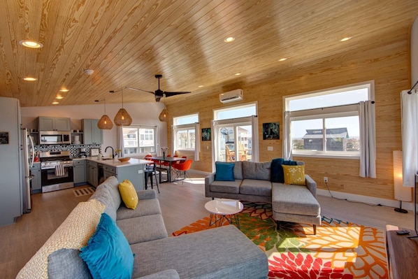 A spacious living area with a kitchen, a dining area, and a sofa set.