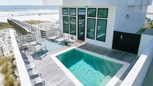 Une maison moderne avec une piscine et une terrasse offrant une vue sur la plage.
