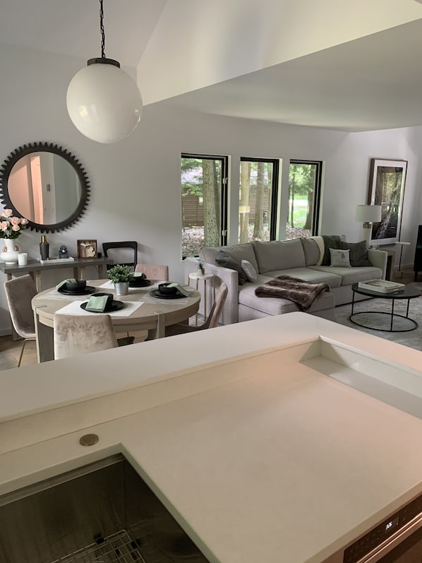 Una sala moderna con comedor, ventanas amplias y chimenea.