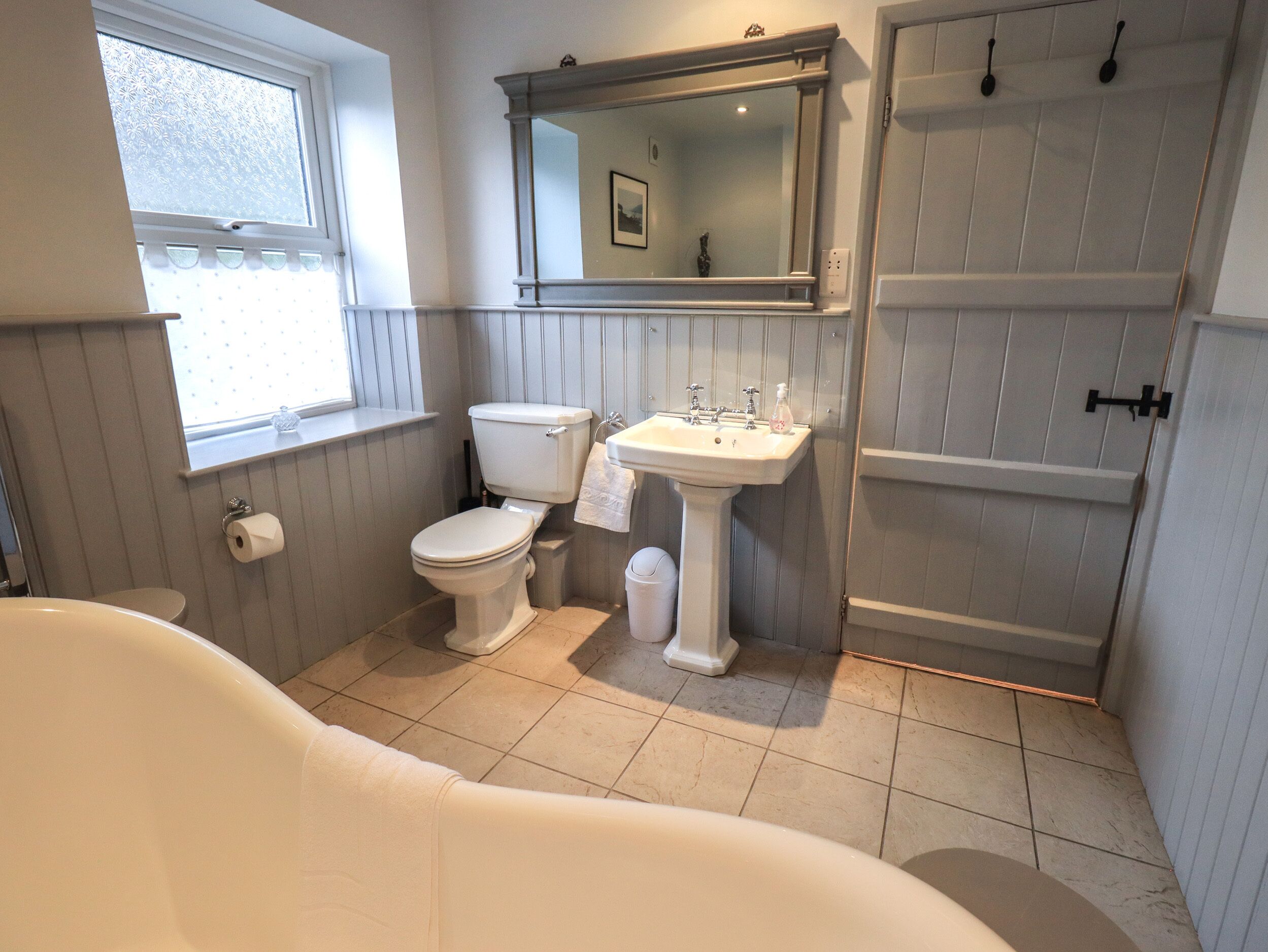 A bathroom with a toilet, sink, and bathtub.