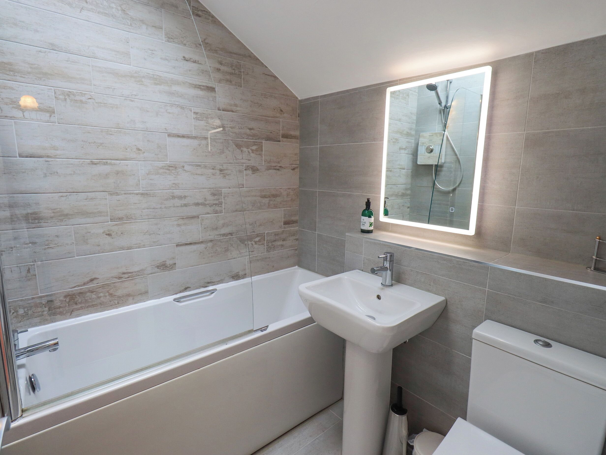 A modern bathroom with a bathtub, sink, and toilet.