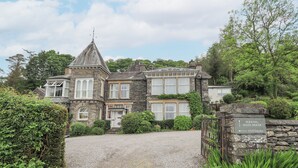 A large, stone-built main house with a prominent turret and multiple windows.