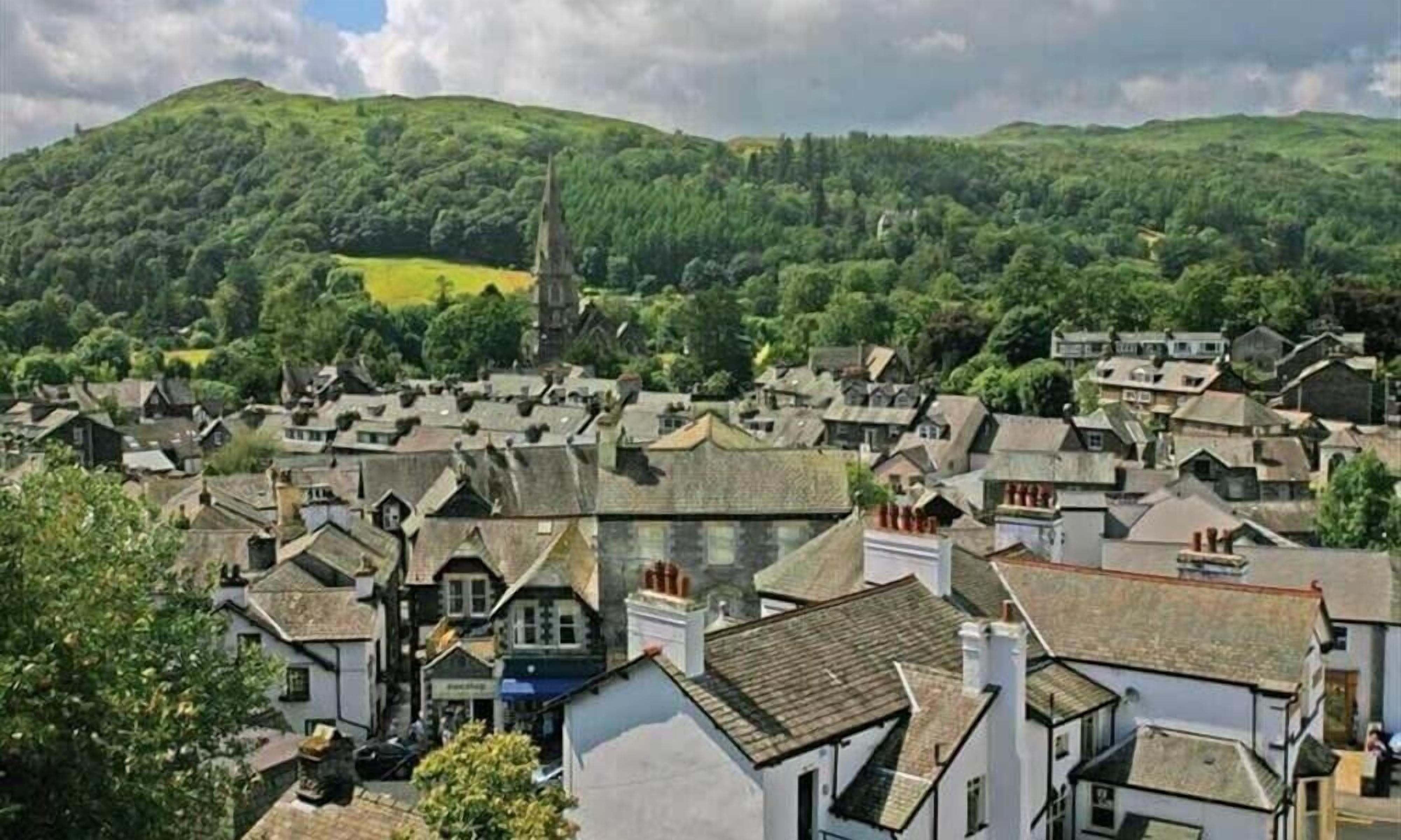 Une ville à l’architecture traditionnelle, avec des bâtiments blancs aux toits en pente et un clocher d’église imposant.