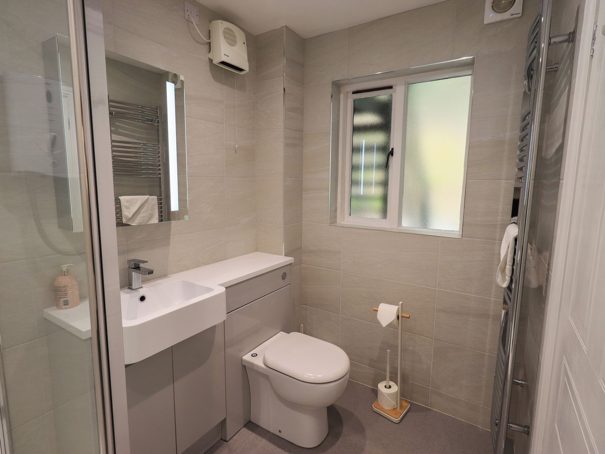 A modern bathroom with a toilet, sink, and shower.