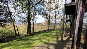 A pathway leading to a building with a view of a grassy area and trees. - Puddleduck (Ambleside)