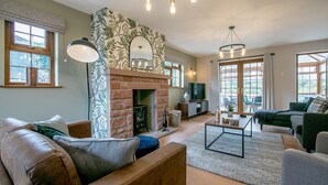 Una sala de estar acogedora con chimenea, asientos cómodos y ventanas amplias.