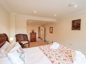A bedroom with a bed, a chair, a dresser, and a painting on the wall. - Oak Bank (Windermere)
