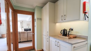 Una cocina moderna con armarios blancos, una encimera y un hervidor.