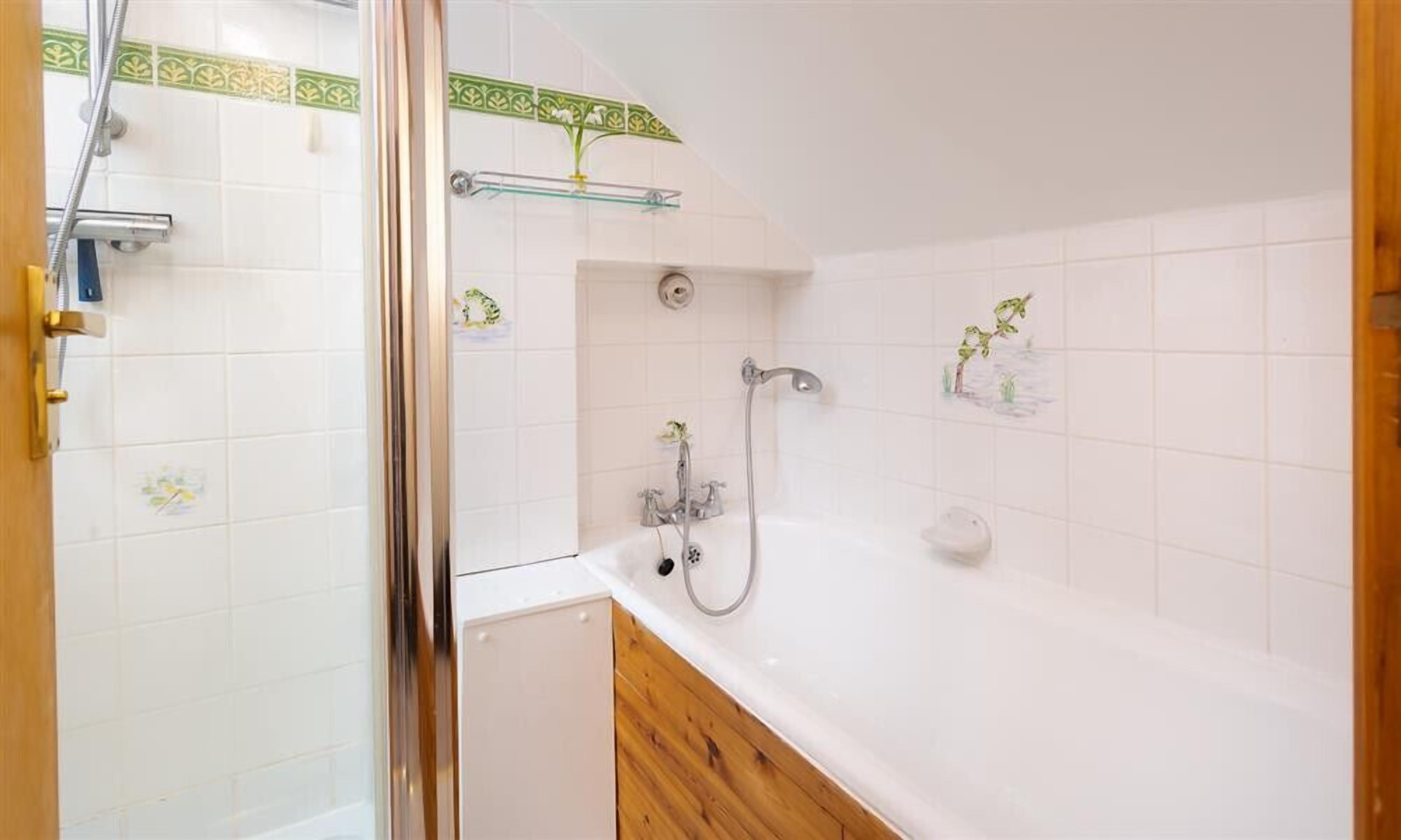 Un bagno con doccia, vasca e servizi igienici.