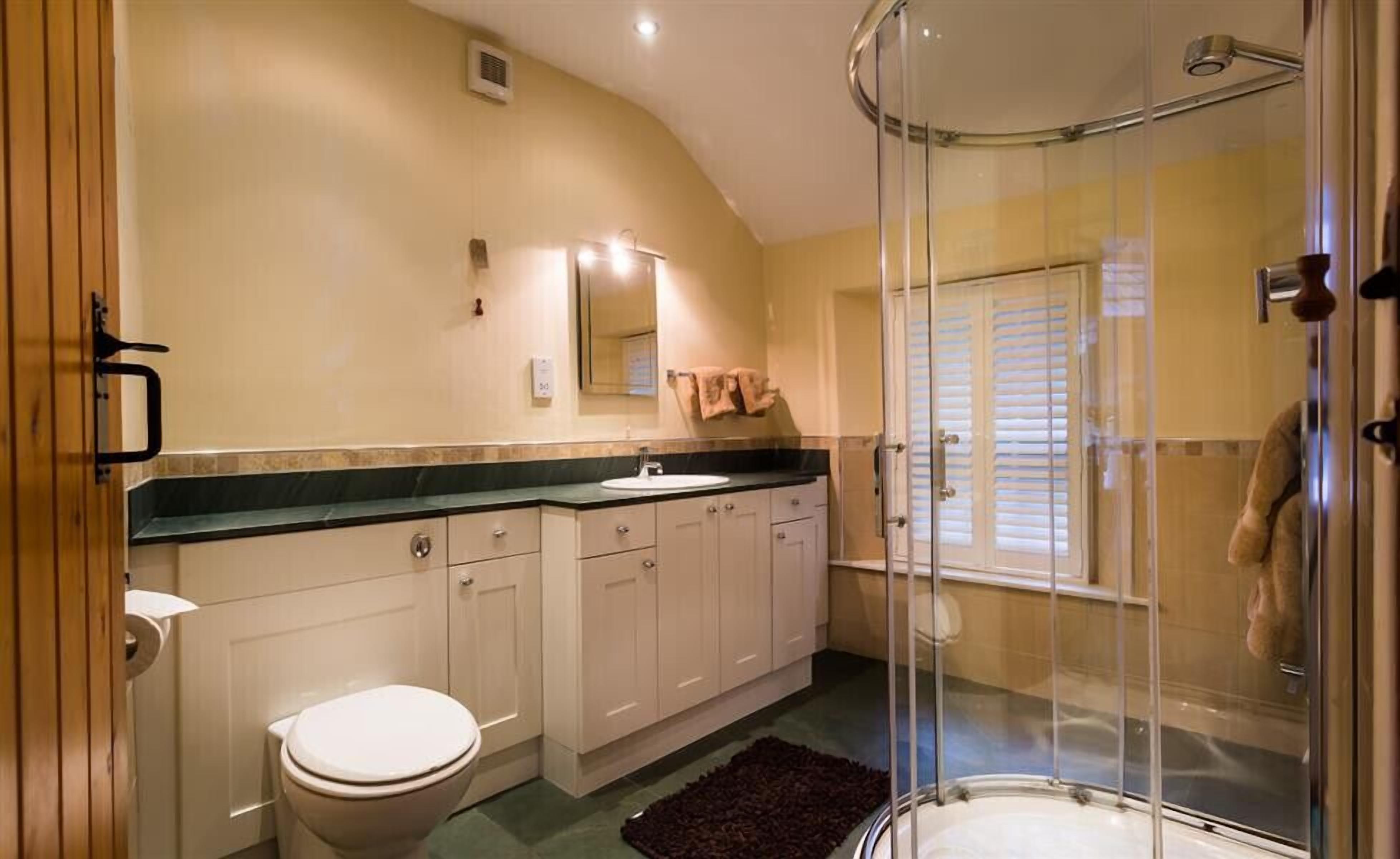 A bathroom with a toilet, sink, and shower.