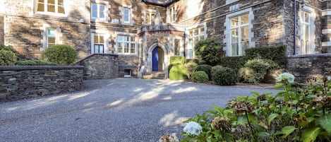 A stone building with a gravel driveway and a blue door.