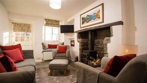 Una sala de estar acogedora con chimenea, asientos cómodos y televisor.