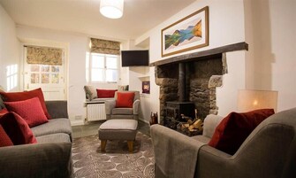 A cozy living room with a fireplace, comfortable seating, and a television.