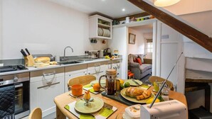 Una cocina compacta con comedor, cafetera y tostadora.