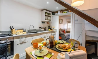 A compact kitchen with a dining area, a coffee maker, and a toaster.