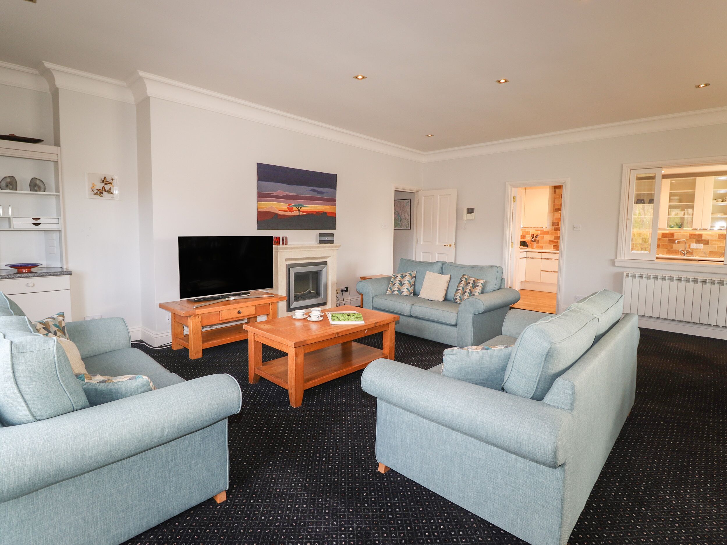 A living room with a TV, fireplace, sofa, and dining table.