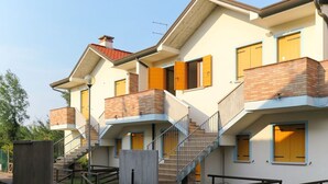 Ein mehrgeschossiges Wohngebäude mit Balkonen, einer Treppe und einer Ziegel-Fassade.