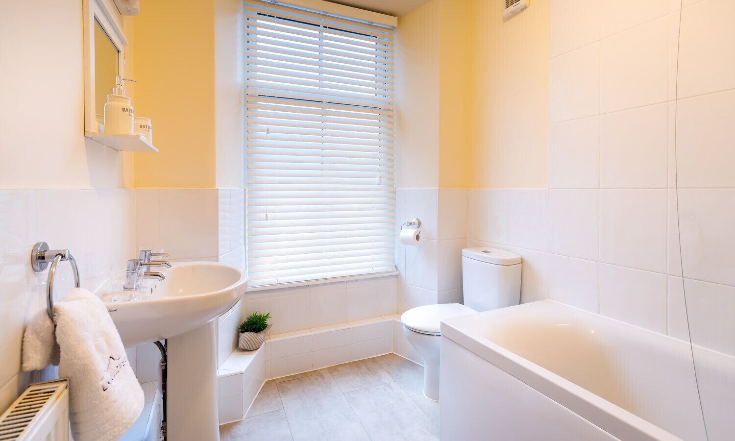 Een moderne badkamer met een wastafel, toilet en bad.