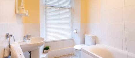 Een moderne badkamer met een wastafel, toilet en bad.