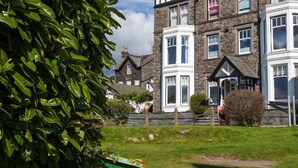A traditional stone building with multiple windows and a prominent bay window. - Waterside (Ambleside)