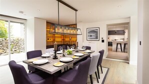 Un espace de restauration moderne avec une longue table dressée pour six personnes, entourée de chaises violettes.