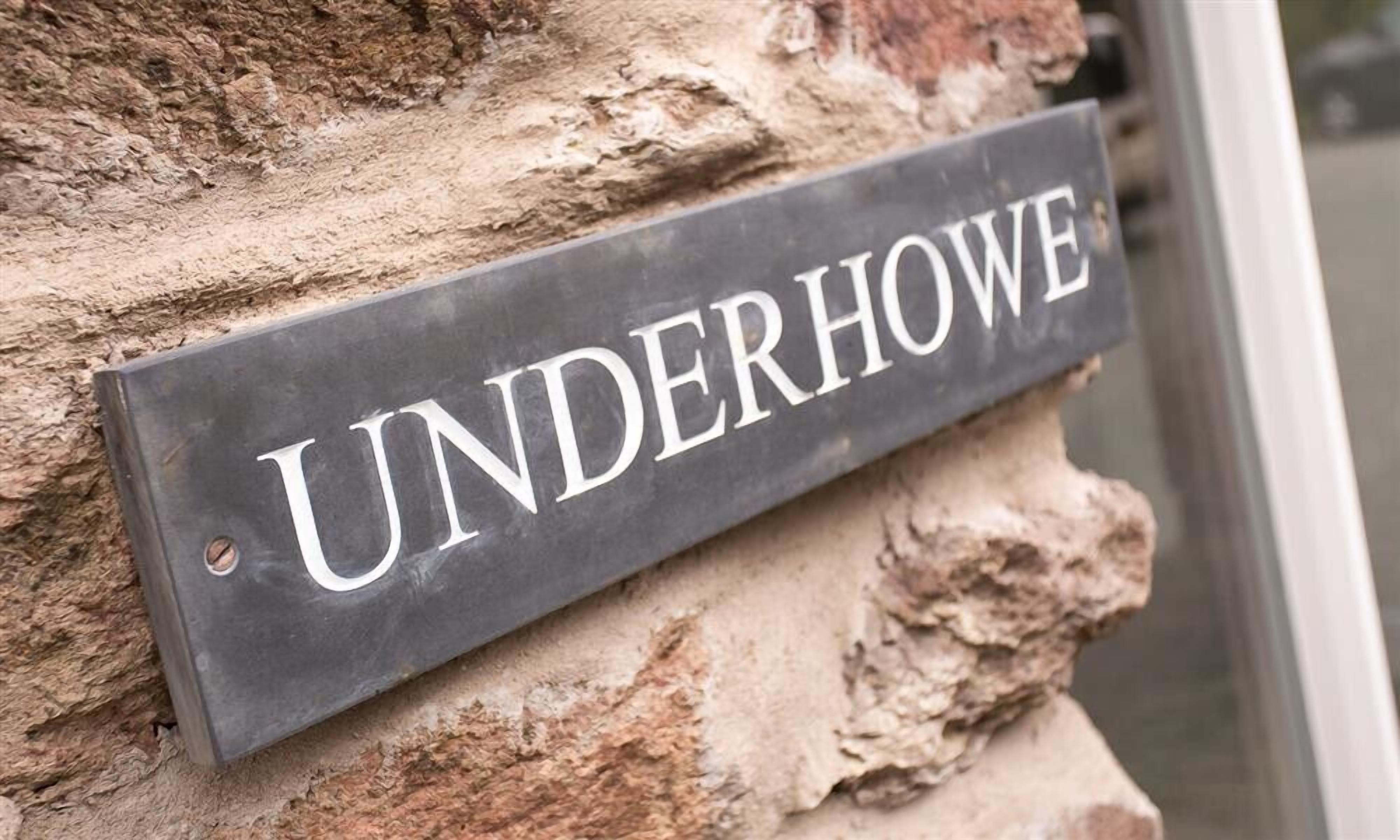 Kadun nimen osoittava kyltti, jossa lukee ”UNDERHOWE”, on kiinnitetty kiviseinään.