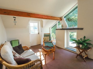 A cozy room with a sofa, a chair, a foosball table, and a potted plant. - Hawkshead Hall (Ambleside)
